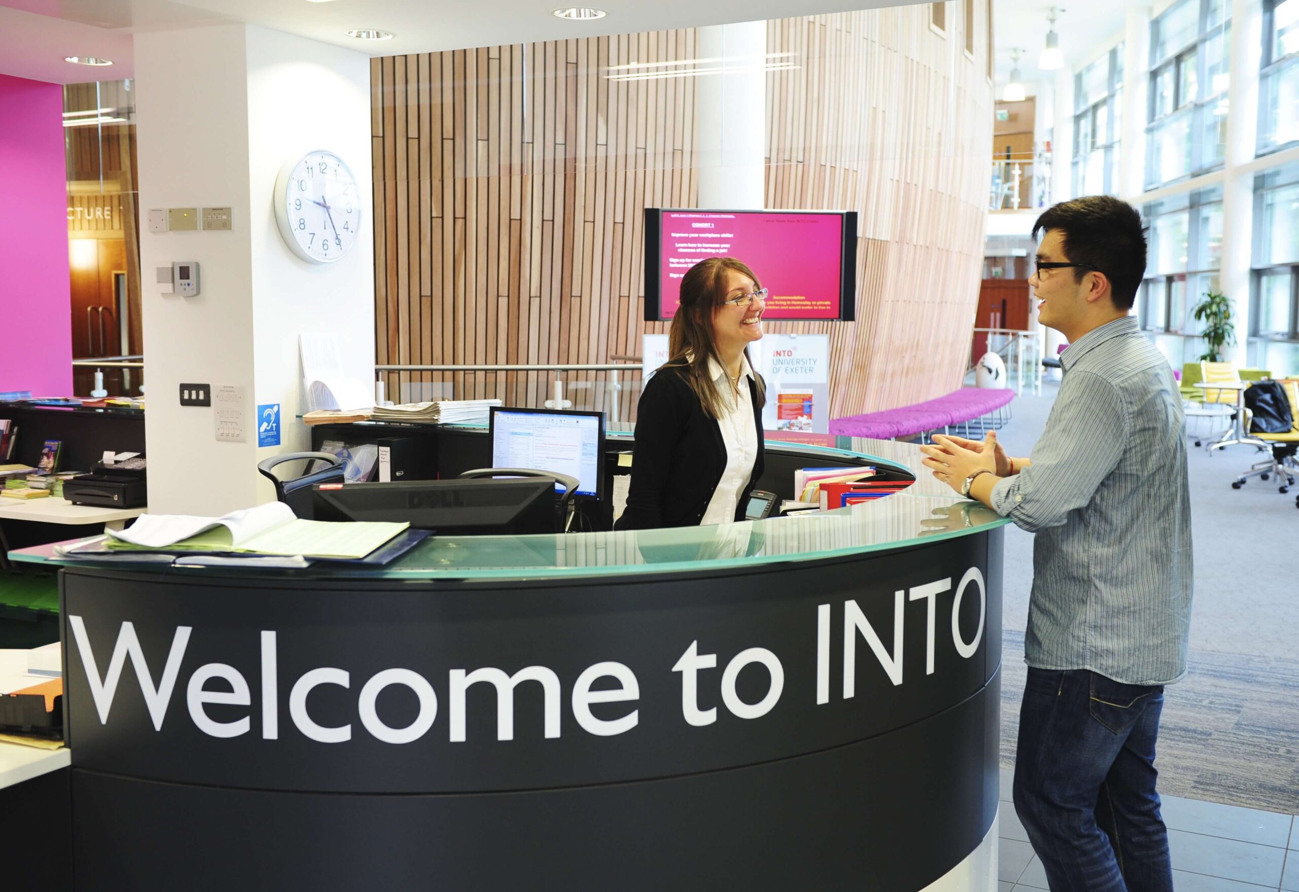 Staff helping student at INTO Exeter Reception